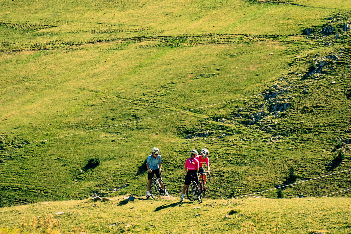 Three riders crossing a green high mountain meadow